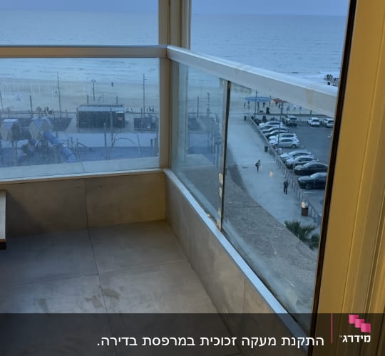 מרפסת עם מעקה זכוכית ונוף לים